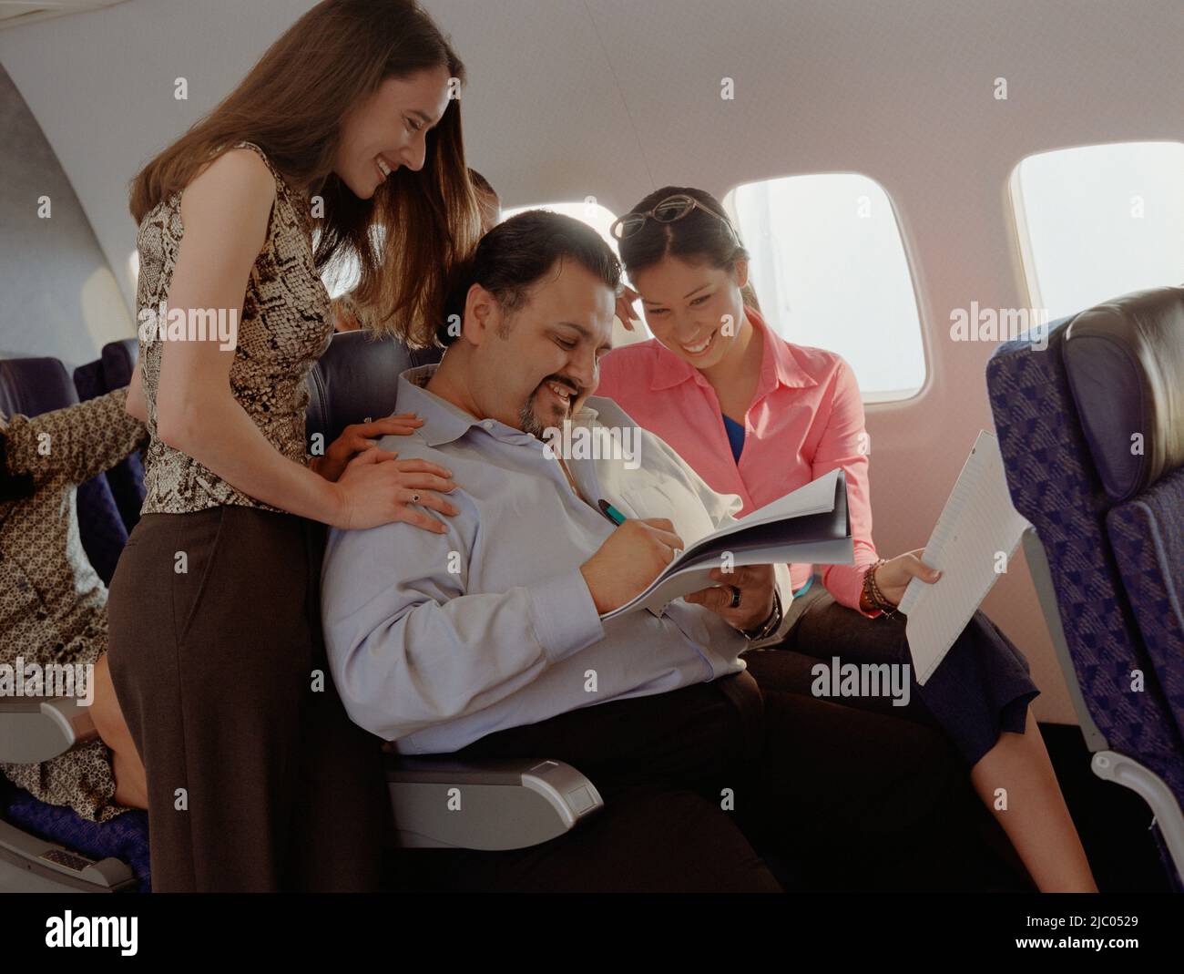 Reifer Mann immer weibliche Aufmerksamkeit auf Flugzeug Stockfoto
