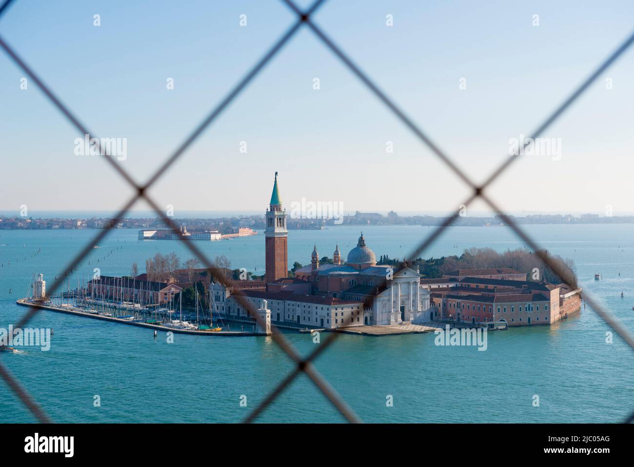 Panoramablick über die Insel San Giorgio Maggiore hinter einem Metallgitter in Venedig, Venetien in Italien. Stockfoto