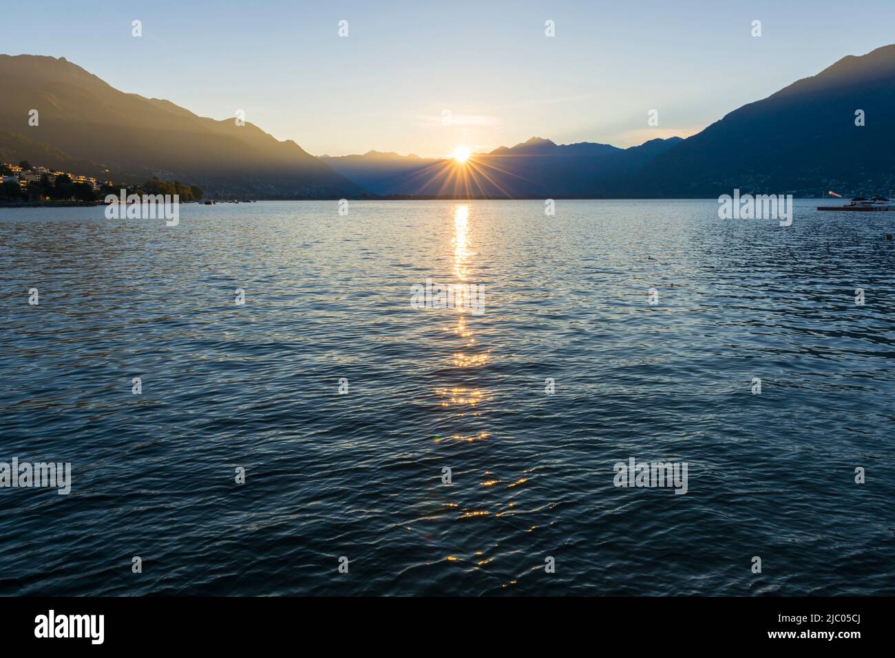 Sonnenstrahl über dem Lago Maggiore mit Berg in Locarno, Schweiz. Stockfoto