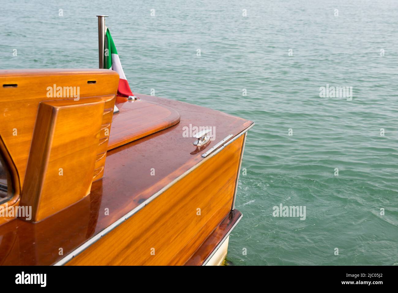 Teil eines luxuriösen und eleganten Holz-Motorboobes mit italienischer Flagge am Mittelmeer in Venedig, Italien. Stockfoto
