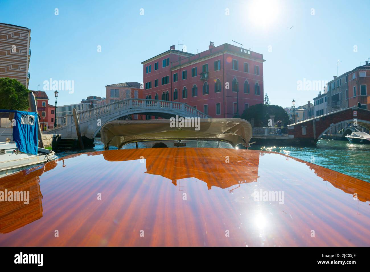 Elegantes Holz Motorboot Reisen Sie auf dem Wasserkanal mit Building in a Sunny Day in Venedig, Venetien in Italien. Stockfoto