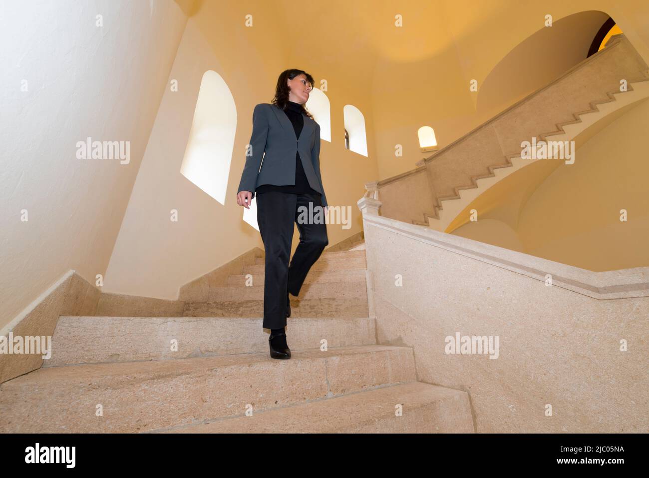 Elegante Frau, die eine Steintreppe in Italien hinabgeht. Stockfoto