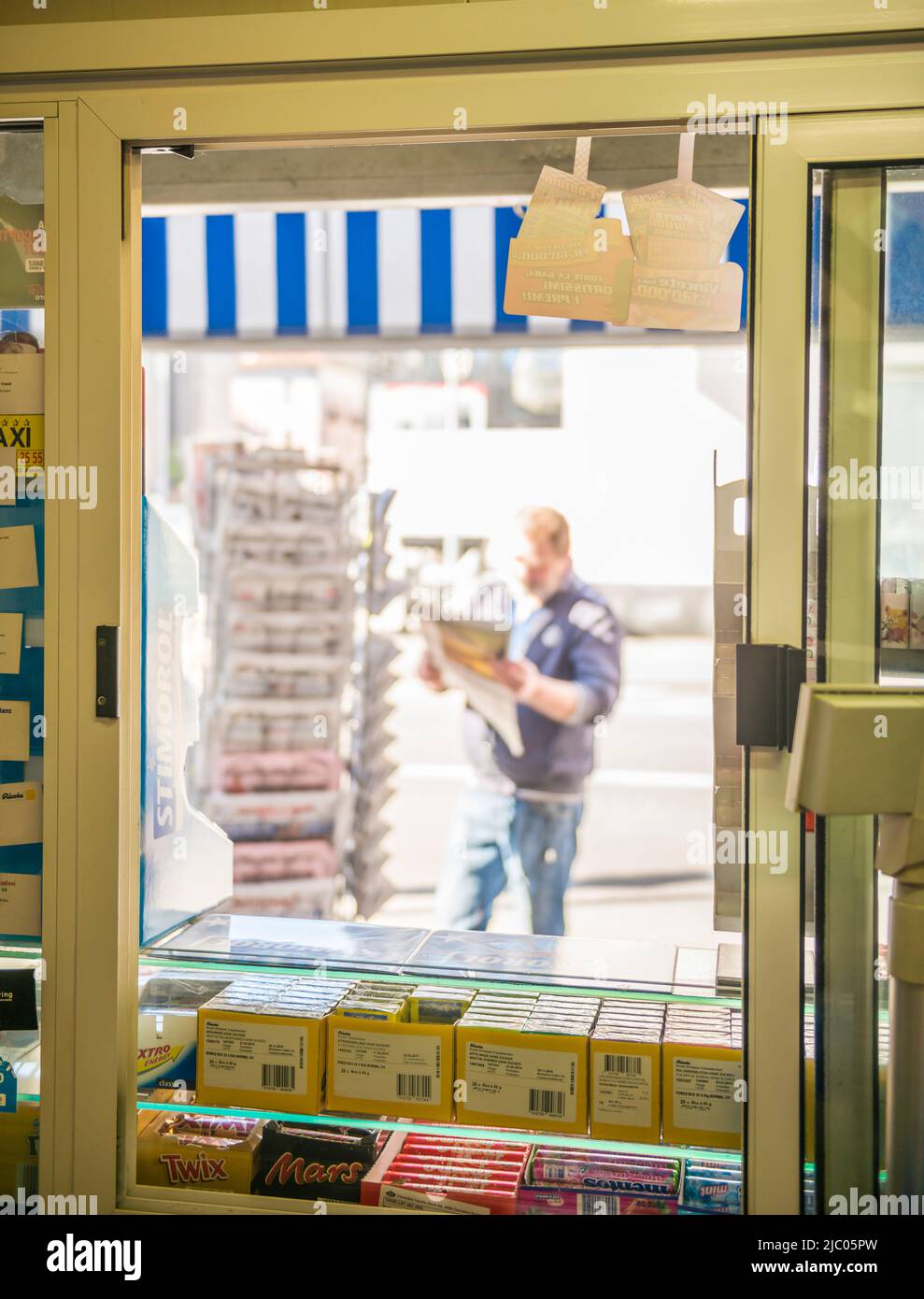 Kiosk und Mann beim Lesen einer Zeitung in der Schweiz. Stockfoto