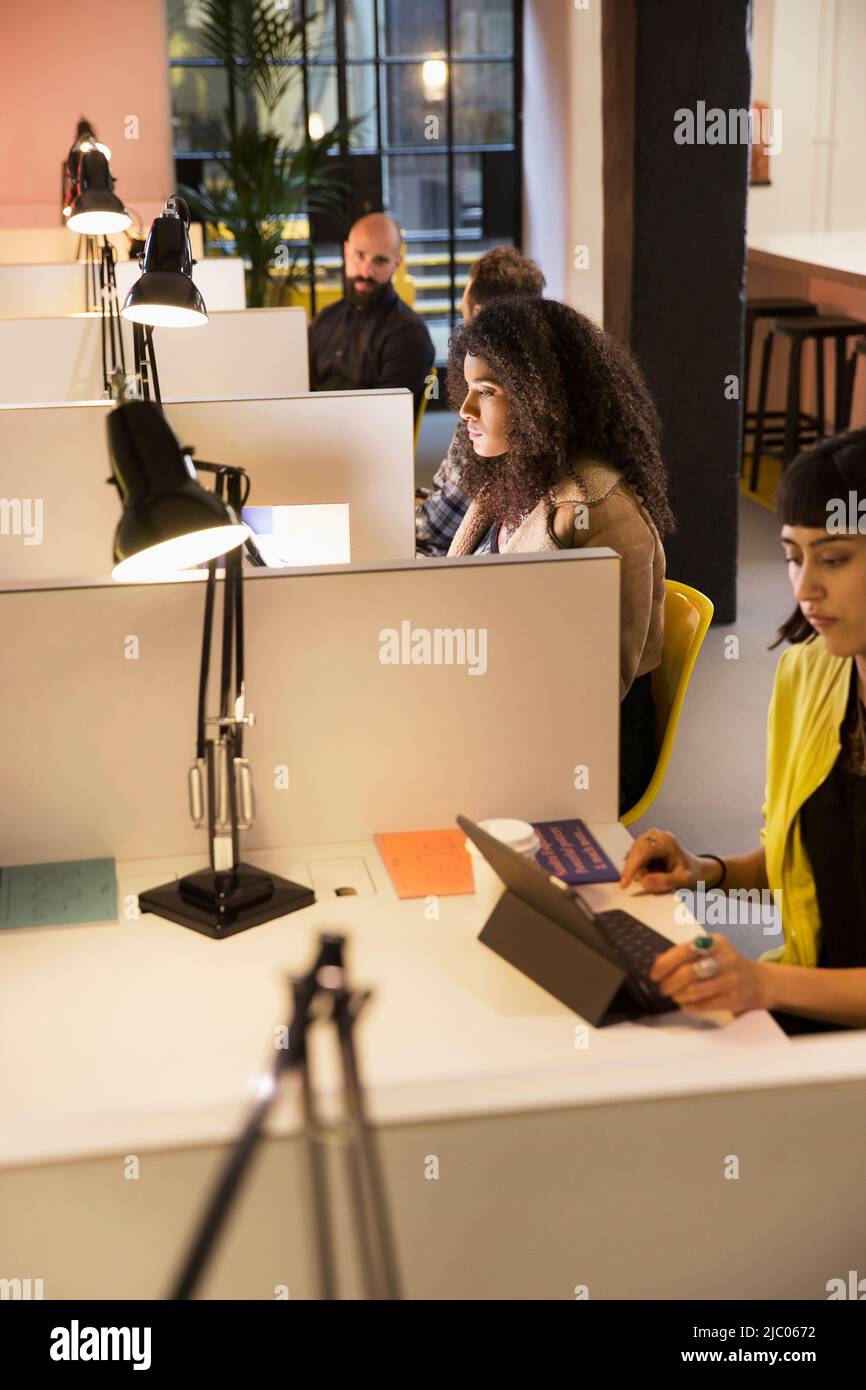 Gruppe von jungen Erwachsenen an einzelnen Arbeitsplätzen im Co-Working-Bereich Stockfoto