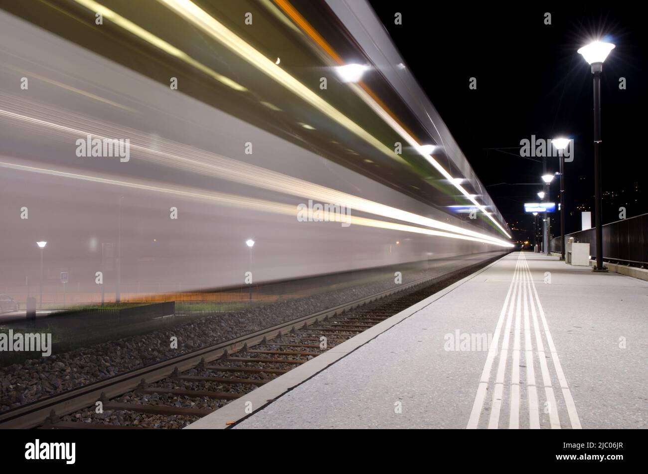 Bahnhof mit einem Zug in Langzeitbelichtung im Tessin, Schweiz. Stockfoto