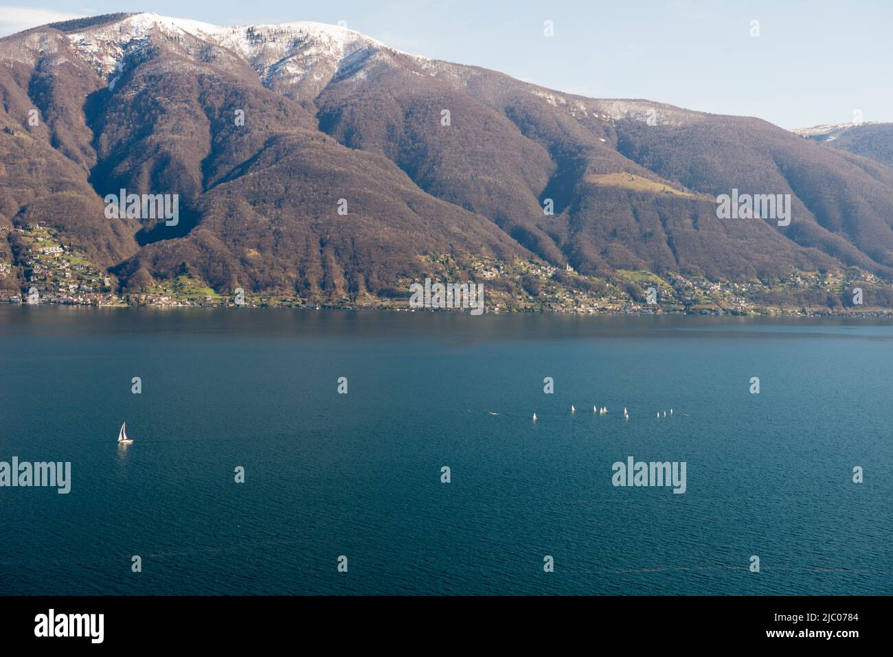 Panoramablick auf den Lago Maggiore mit schneebedecktem Berg und Segelboot in Ascona, Schweiz. Stockfoto