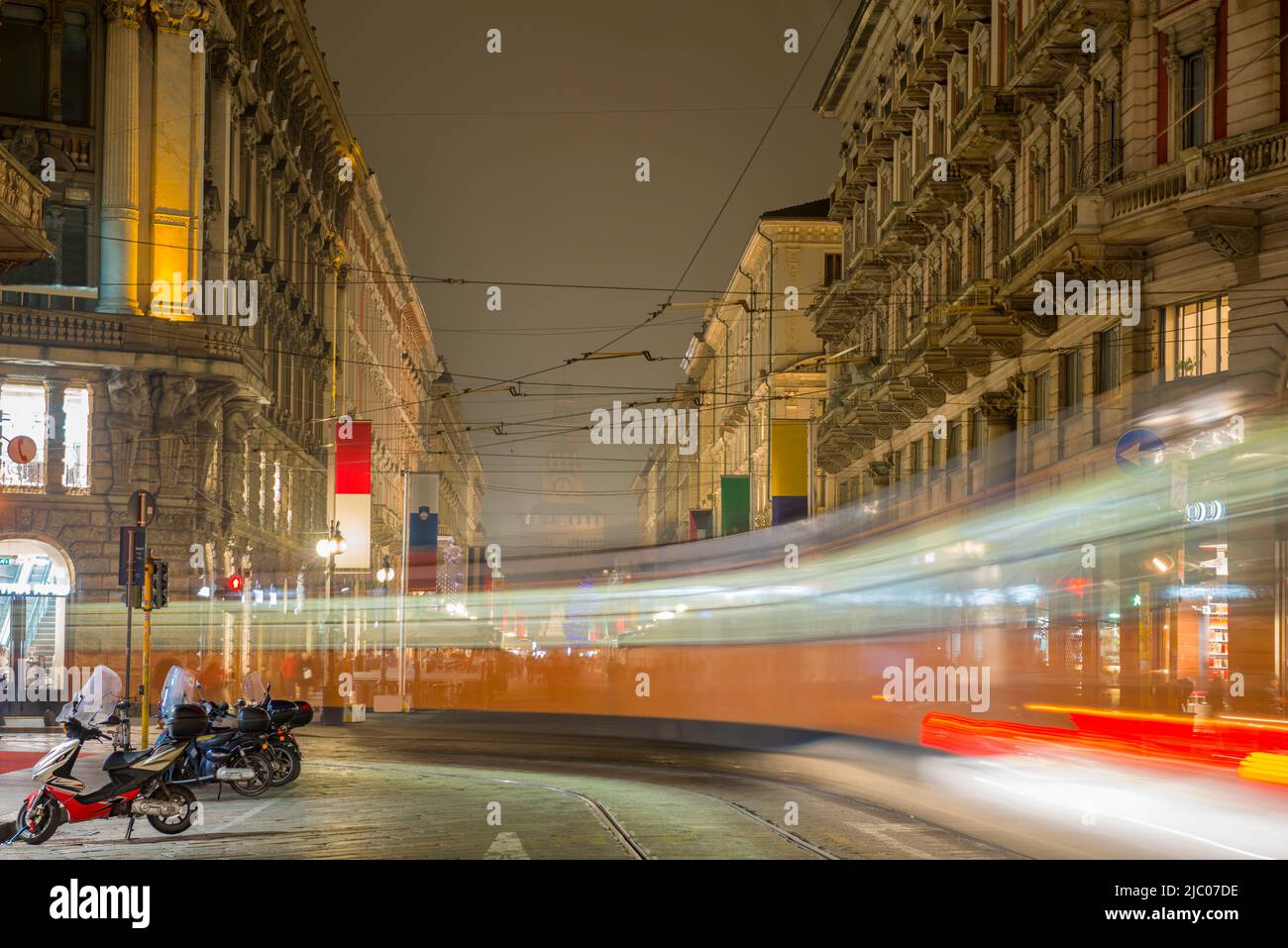 Stadtbild mit einer Straßenbahn in Langzeitbelichtung in der Dämmerung in Mailand, Lombardei in Italien. Stockfoto