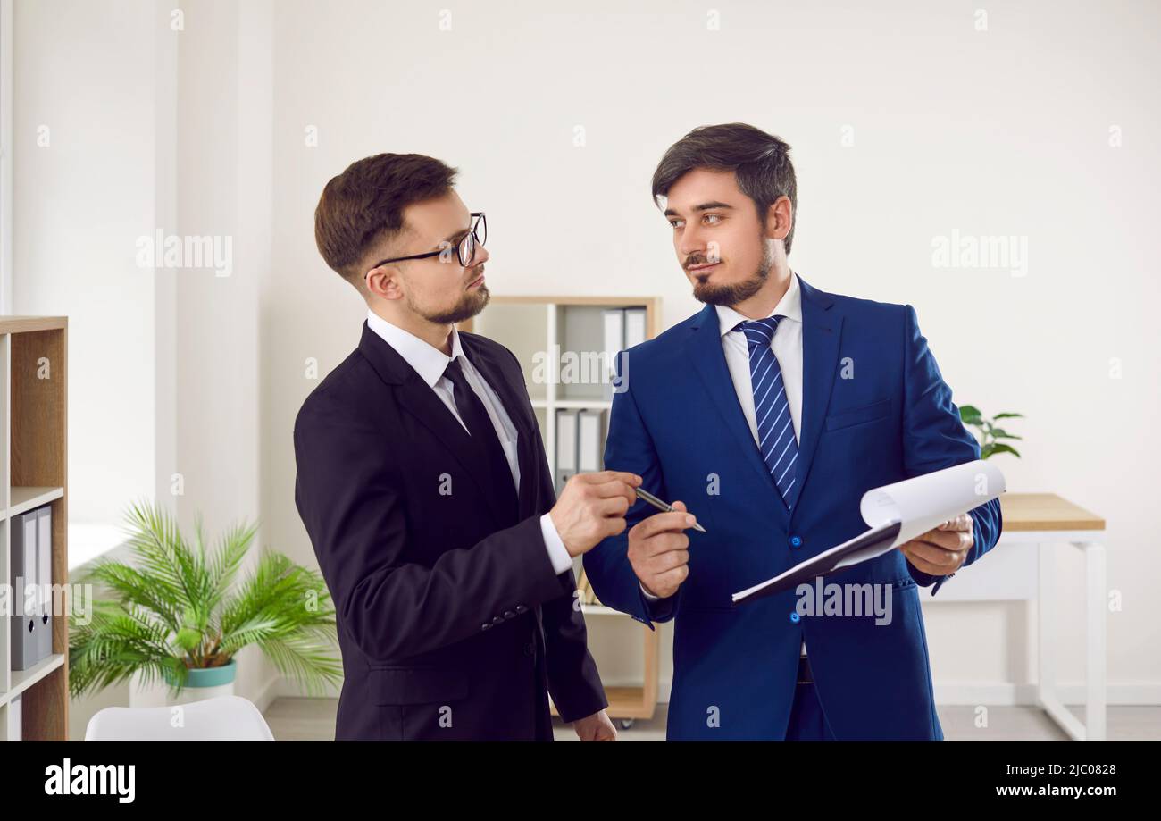 Männlicher Anwalt im Büro gibt dem Kunden Stift, um Vertrag oder Vertragsdokument zu unterzeichnen. Stockfoto