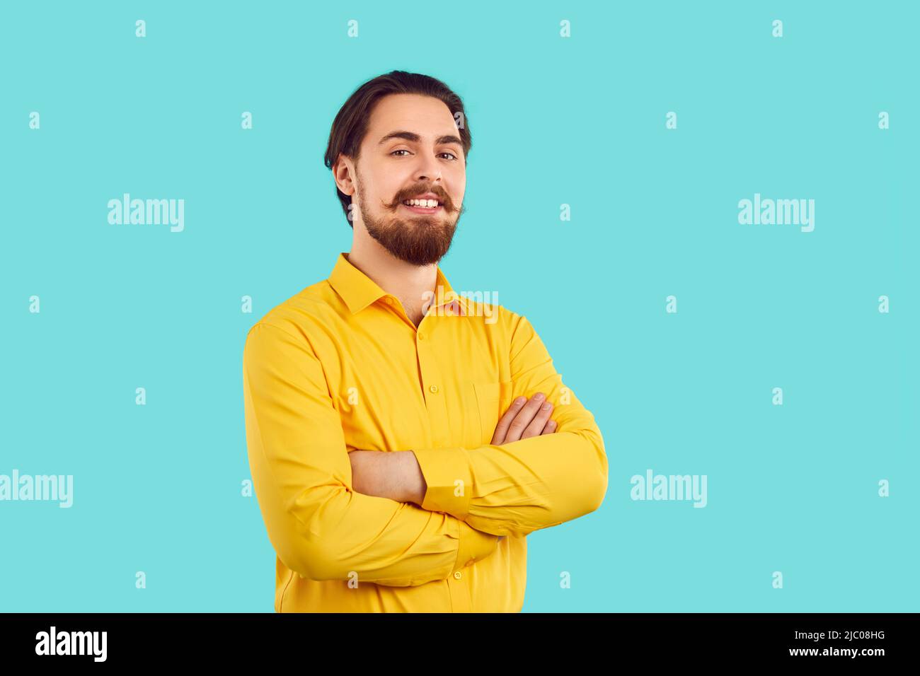 Porträt eines gutaussehenden und glücklichen Mannes mit stilvollem Schnurrbart und Bart auf hellblauem Hintergrund. Stockfoto