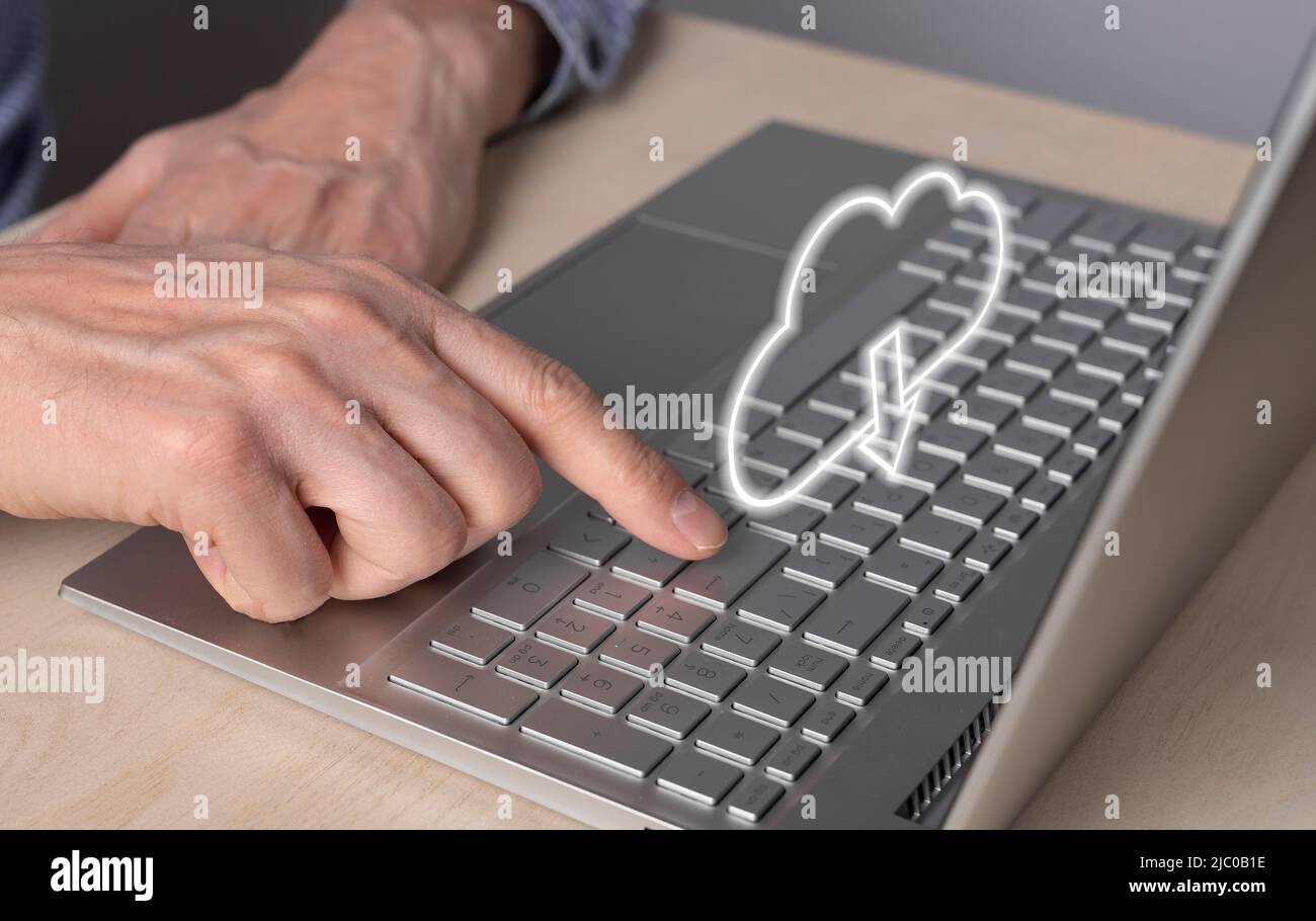 Cloud-Computing. Mann mit Laptop zum Abrufen von Dateien aus dem Online-Speicher. Nahaufnahme des Zeigefingers durch Drücken der ENTER-Taste. Hochwertige Fotos Stockfoto
