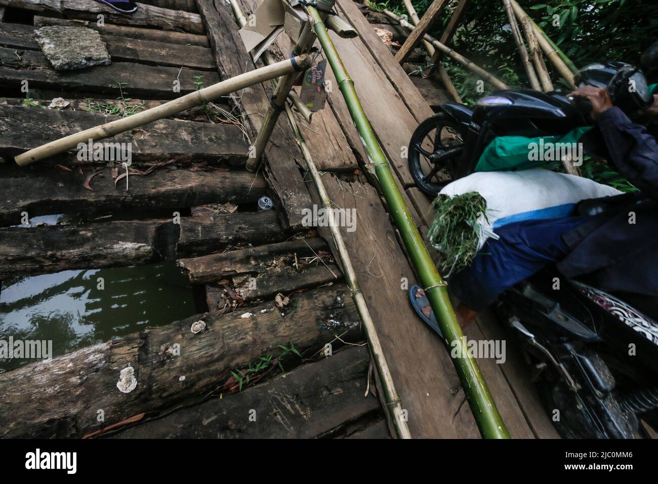 Am 7. Juni 2022 überqueren die Bewohner eine beschädigte Brücke im Gebiet Bogor, West-Java, Indonesien Stockfoto