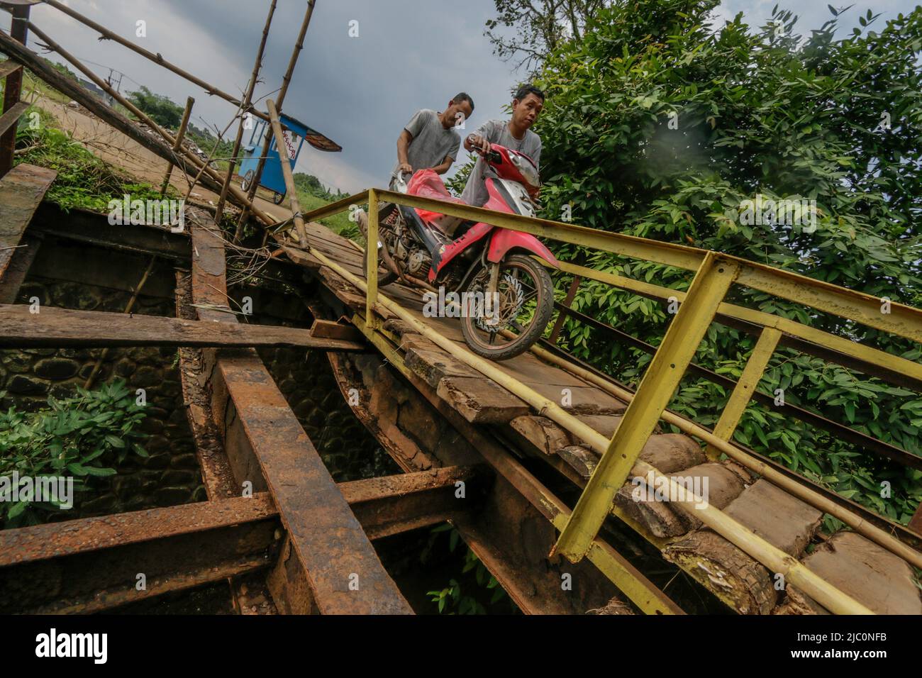 Am 7. Juni 2022 überqueren die Bewohner eine beschädigte Brücke im Gebiet Bogor, West-Java, Indonesien Stockfoto