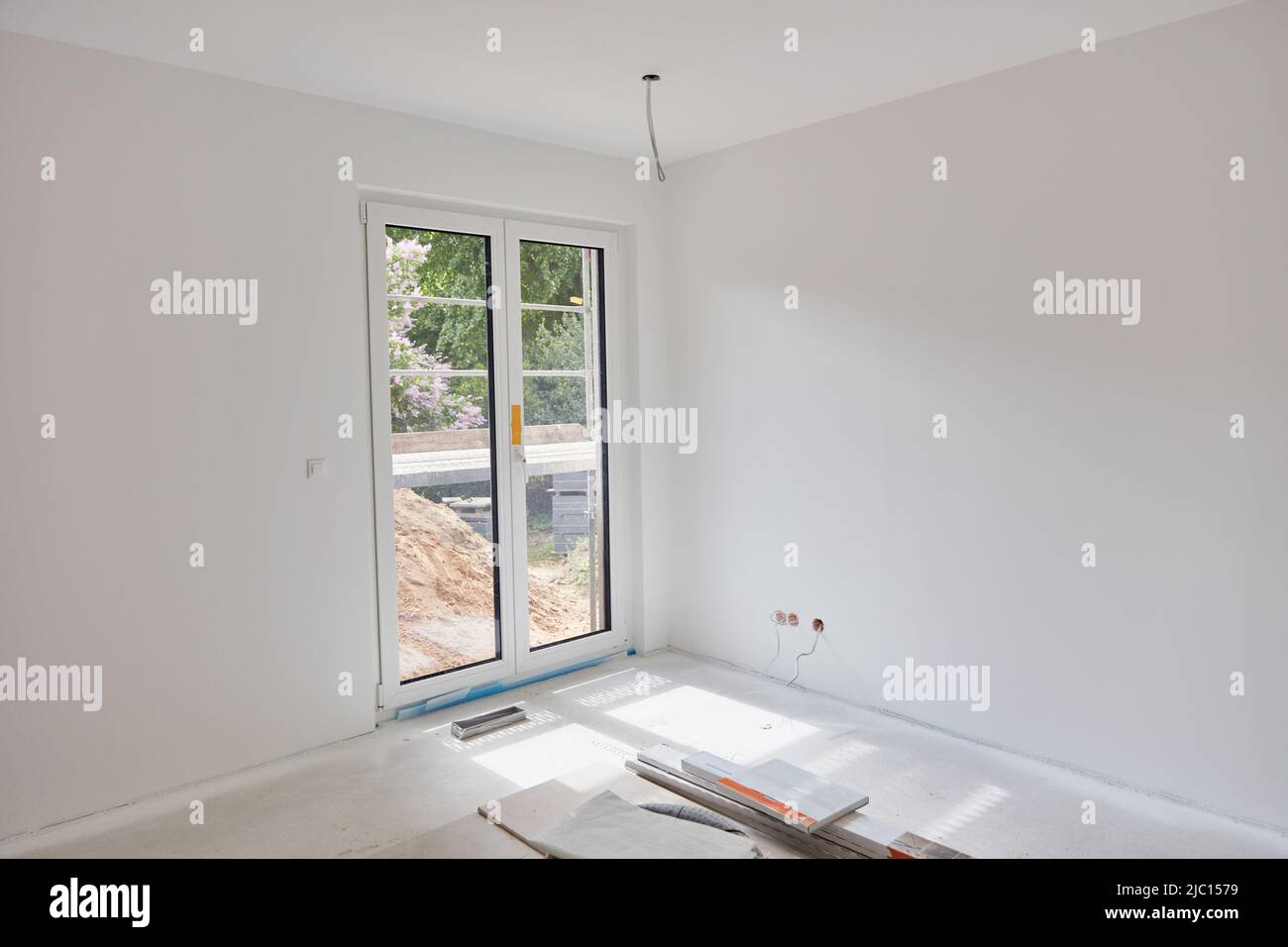 Weißes, leeres Zimmer mit Terrassentür nach dem Anstreichen der Bauarbeiten zu Hause Stockfoto