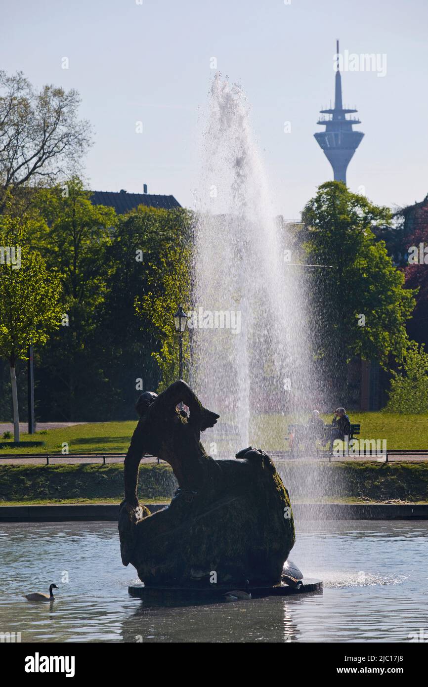 Skulptur 'Jroene Jong' im runden Teich des Düsseldorfer Hofgartens, Rheinturm im Hintergrund, Deutschland, Nordrhein-Westfalen, Unteren Stockfoto