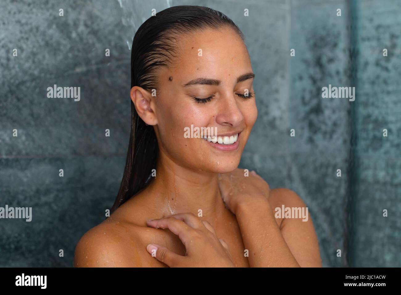 Nahaufnahme einer kaukasischen jungen Frau, die zu Hause im Badezimmer duscht Stockfoto