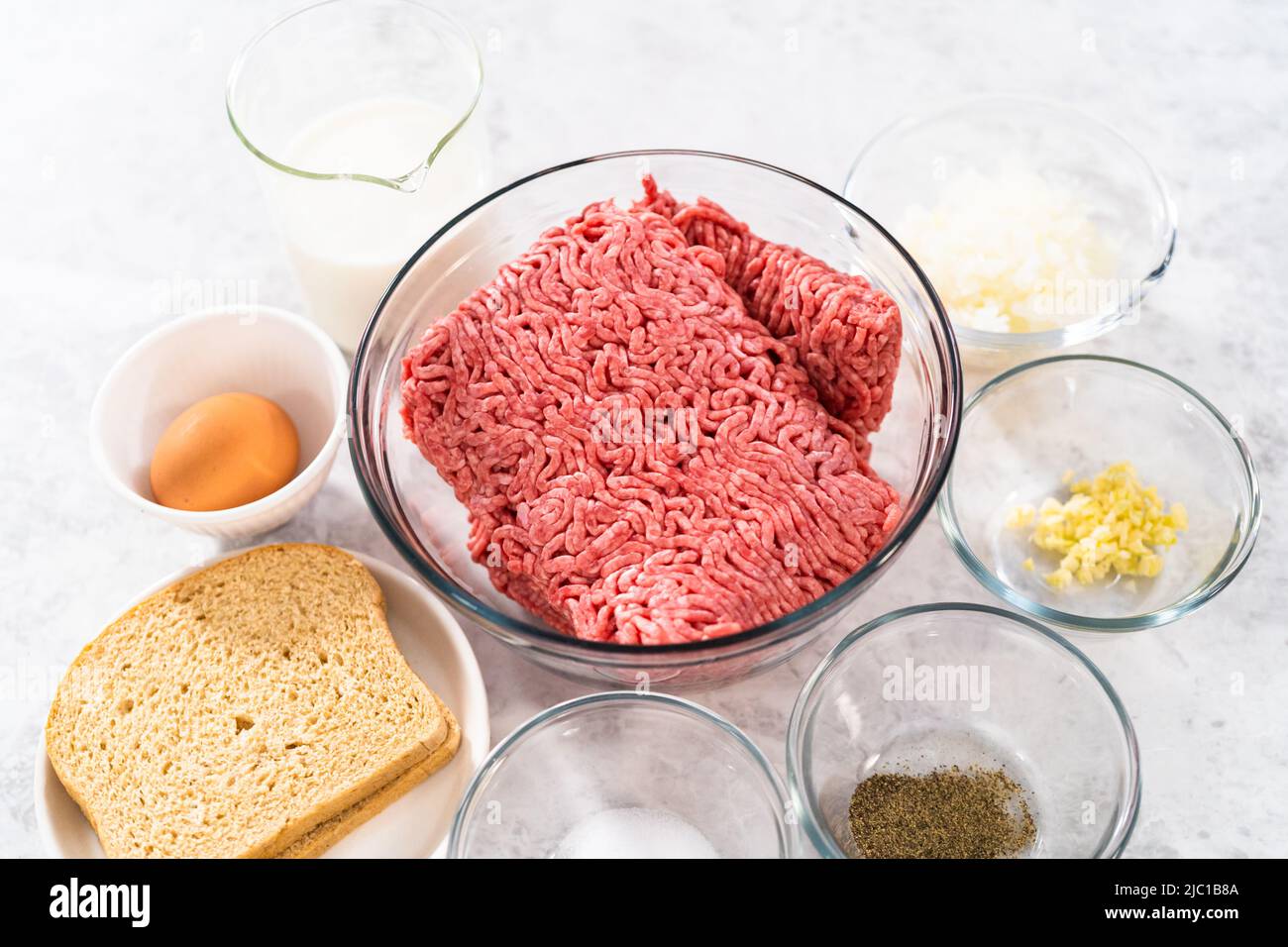 Gemessene Zutaten in Glasschüsseln, um Hackbraten zu machen. Stockfoto