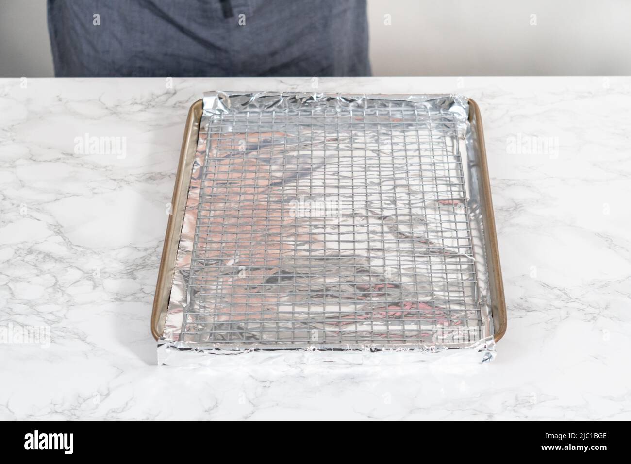 Rohe Hummerschwänze auf einem Backblech mit Küchenfolie, fertig zum Backen im Ofen. Stockfoto