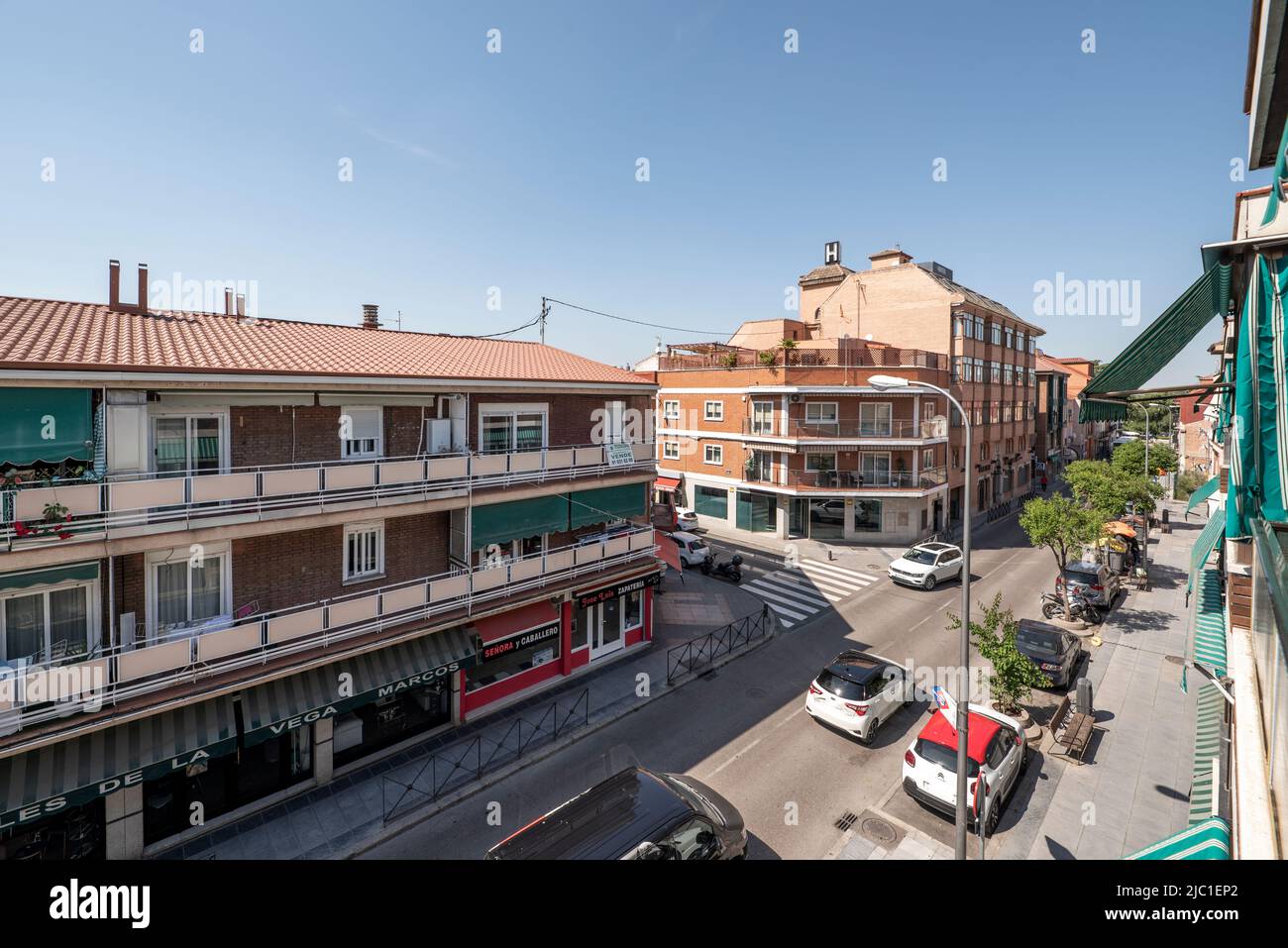 Straße mit dreistöckigen Häusern mit Markisen auf den Terrassen Stockfoto