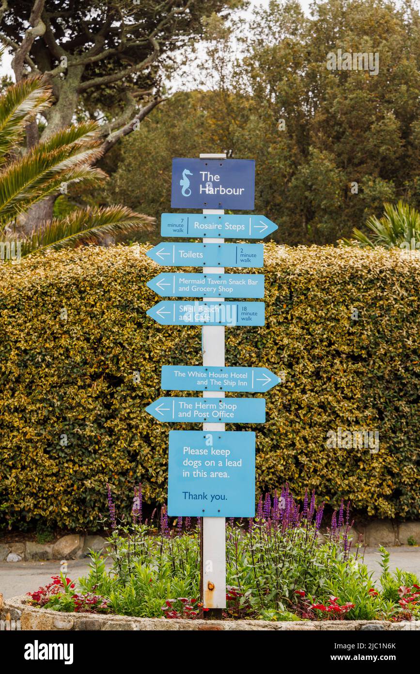 Blauer Wegweiser im Hafen mit Anweisungen zu den Attraktionen von Herm, einer Insel in der Bailiwick von Guernsey, Kanalinseln, Großbritannien Stockfoto
