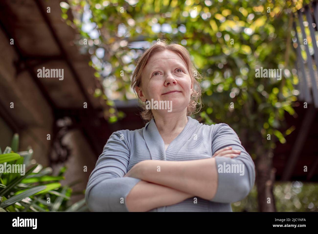 Aus der Perspektive einer reifen Frau, die im Garten steht und denkt Stockfoto