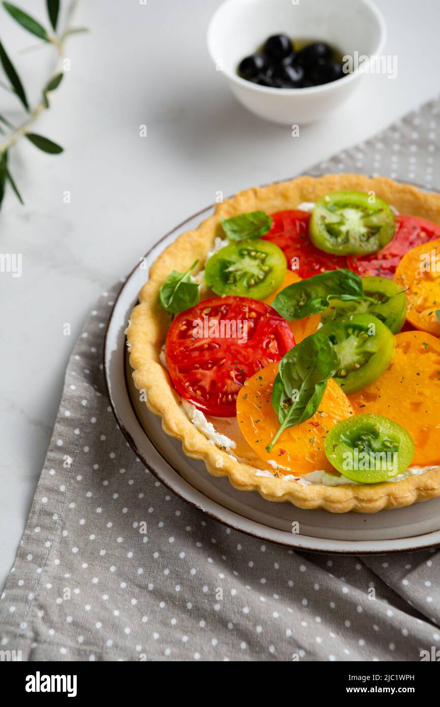Nahaufnahme der geschnittenen Ricotta-Quiche-Tomate auf dem Teller Stockfoto