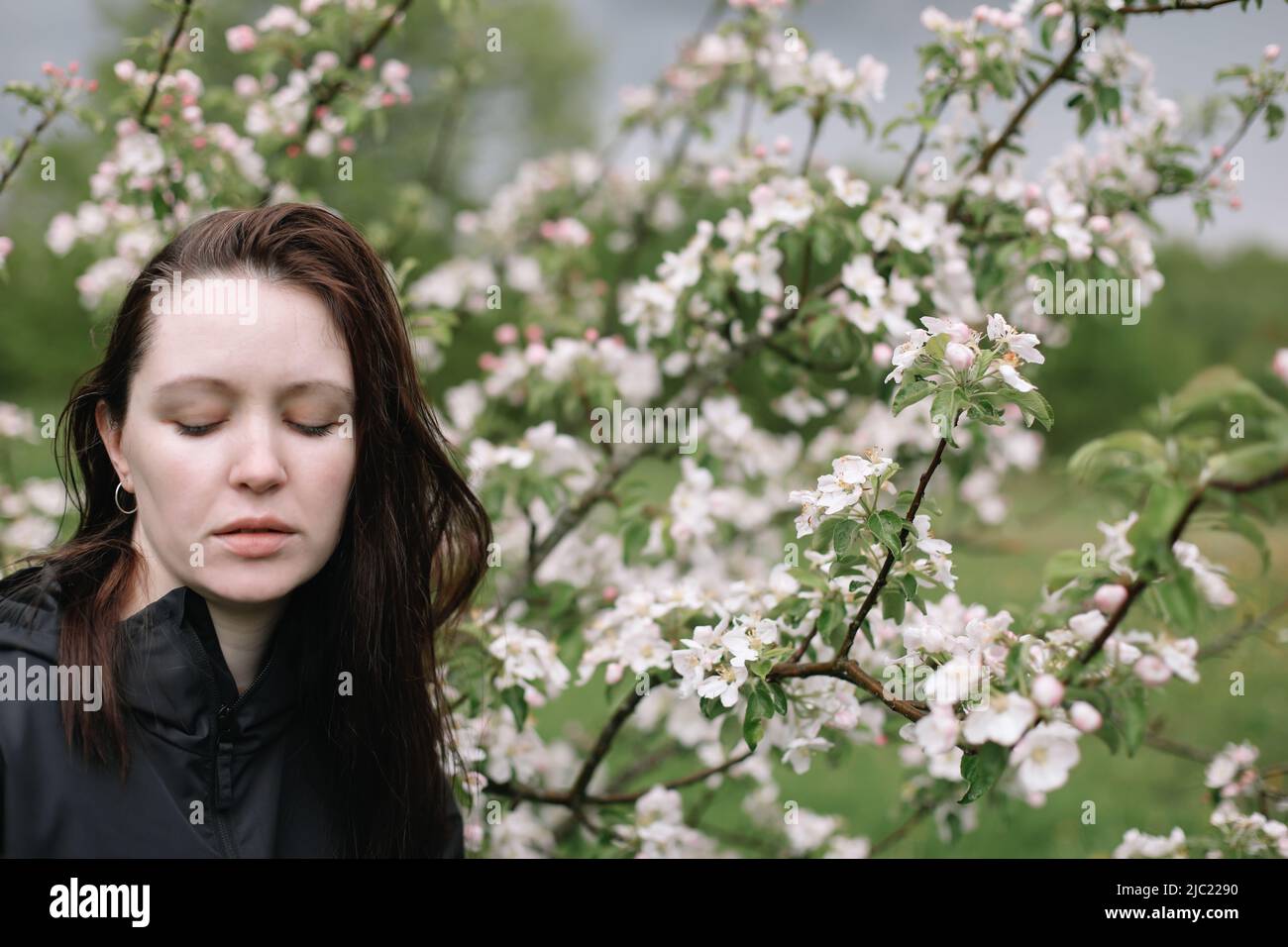 Porträt einer schönen jungen Frau im Frühlingsgarten inmitten der Apfelblüte. Stockfoto