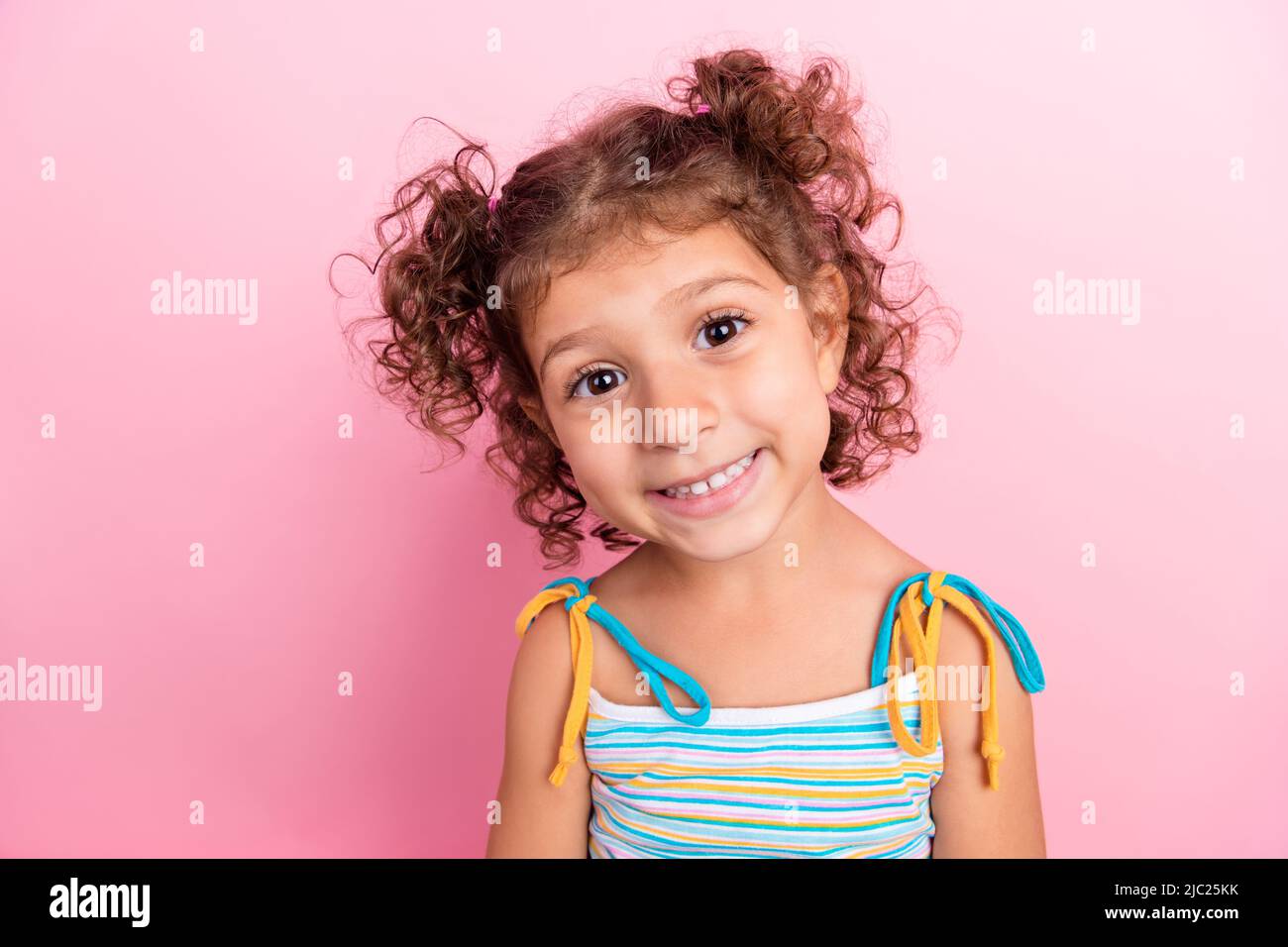 Porträt von attraktiven fröhlich wellig-haarige Mädchen preteen Blick auf Kamera isoliert über rosa Pastellfarben Hintergrund Stockfoto