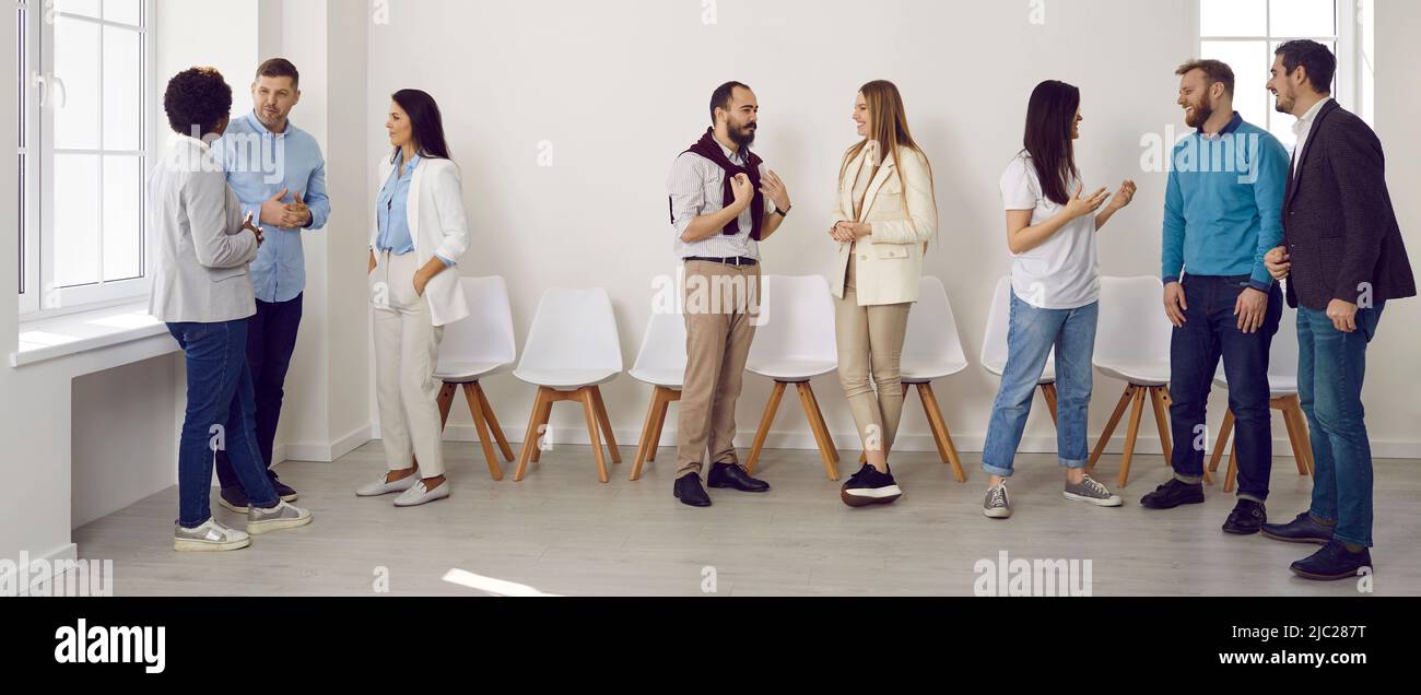 Eine Gruppe junger Menschen, die sich bei einer geschäftlichen Veranstaltung im Büro treffen und miteinander kommunizieren Stockfoto