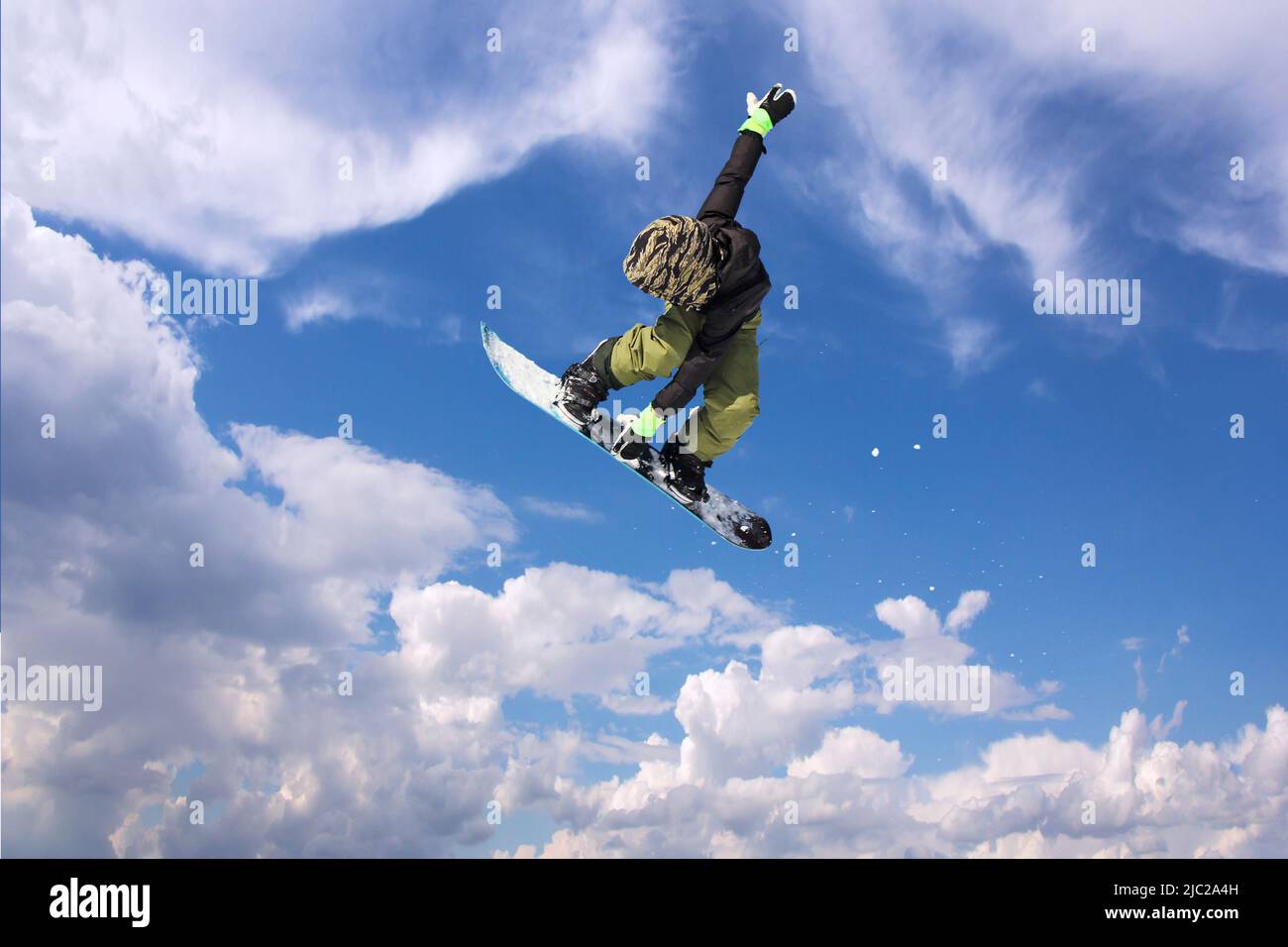 Snowboarder in Aktion, springen gegen blauen Himmel Stockfoto
