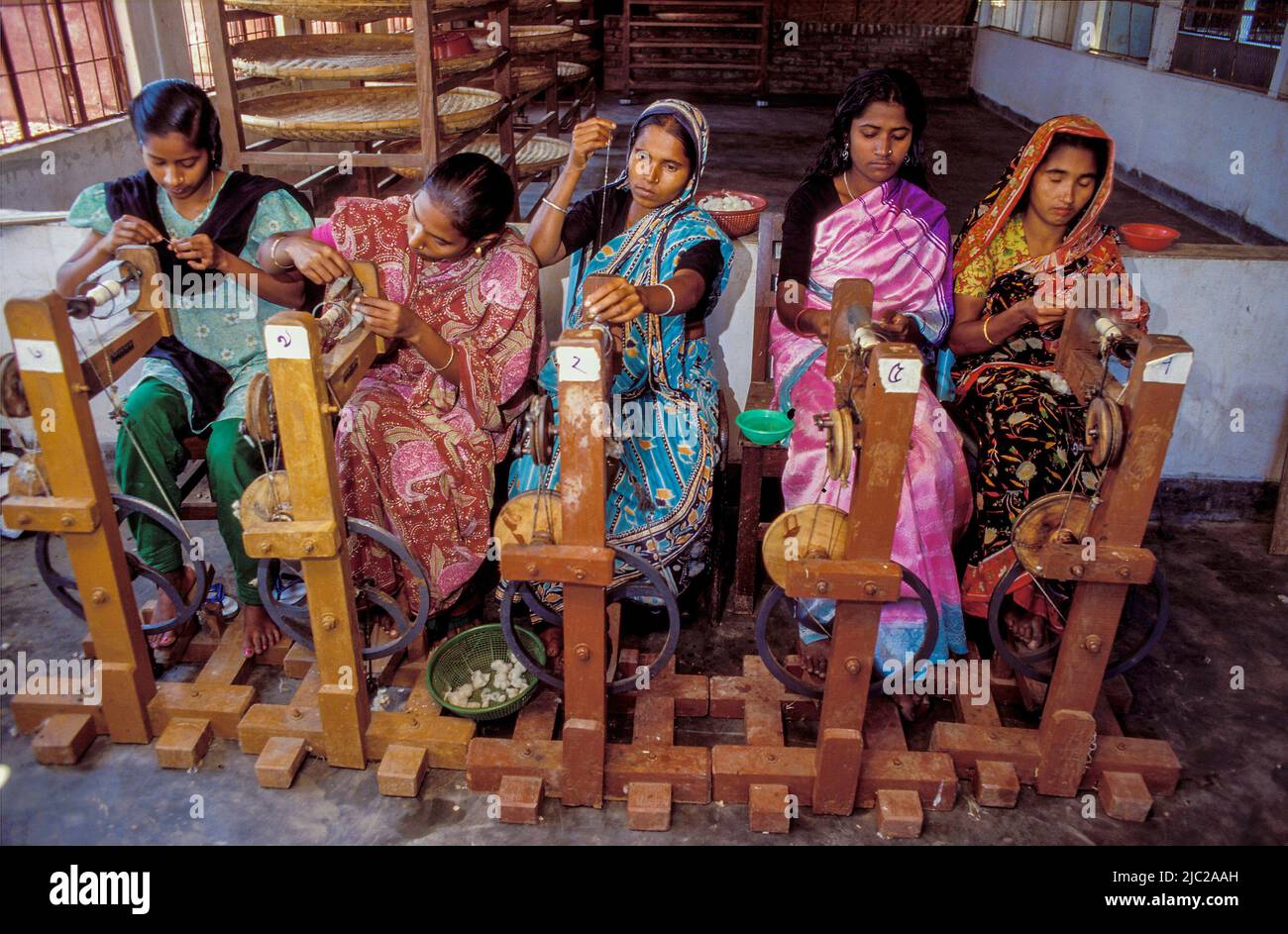 Bangladesch; Frauen in einer Fabrik, die am Spinnrad arbeitet. Stockfoto