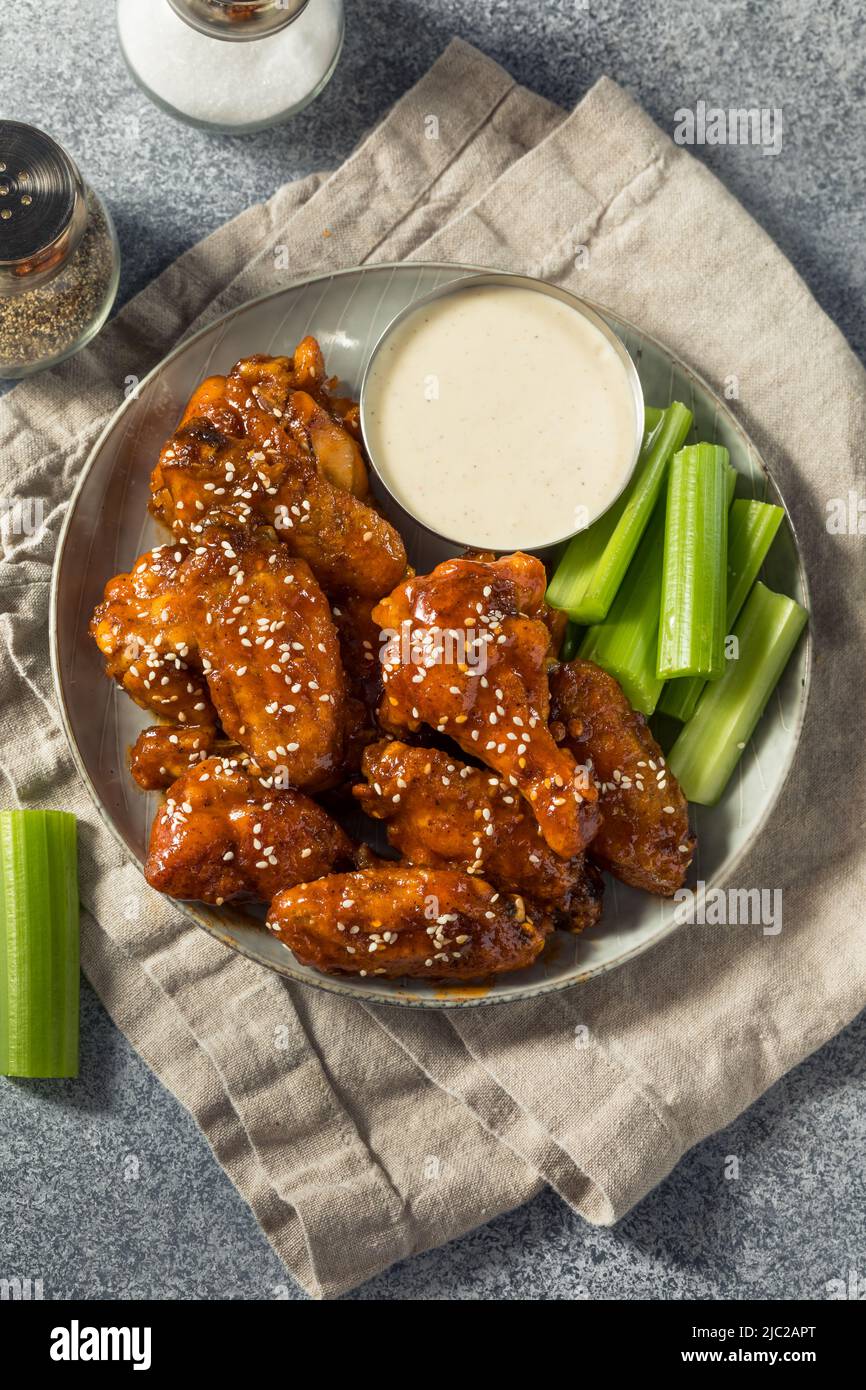 Hausgemachte Sriracha Honey Chicken Wings mit Sesam und Ranch Stockfoto