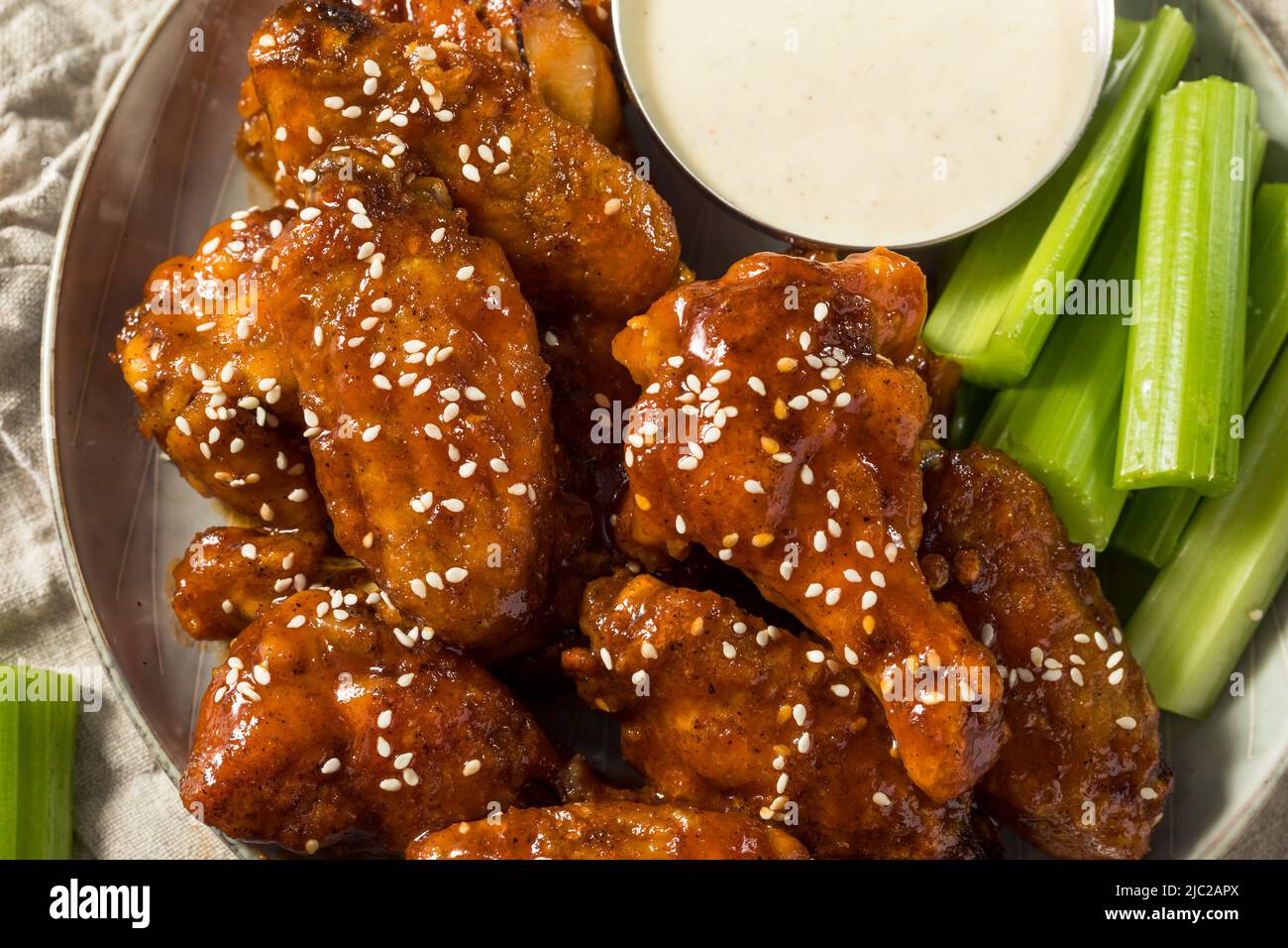 Hausgemachte Sriracha Honey Chicken Wings mit Sesam und Ranch Stockfoto
