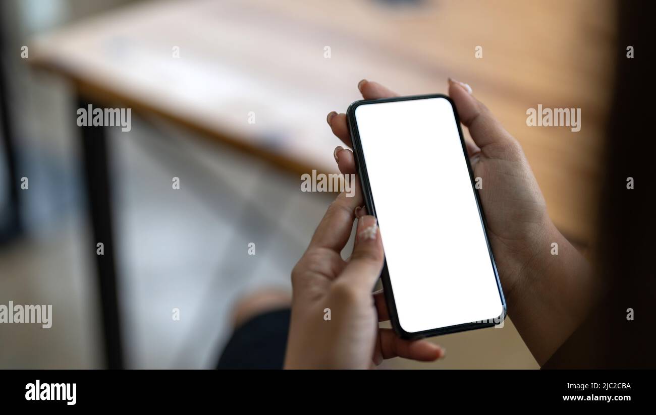Handy in Frauenhand mit weißem Bildschirm nachgestellt Stockfoto