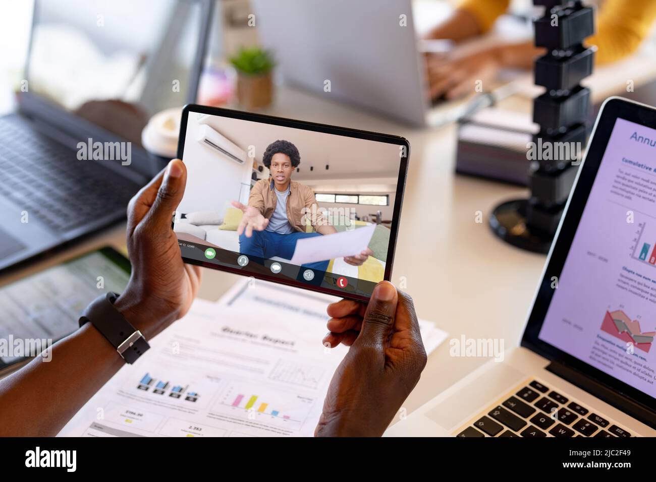 afroamerikanischer Geschäftsmann informiert über Arbeitsplan für männlichen Kollegen, der auf dem Bildschirm des digitalen Tablets gesehen wird Stockfoto