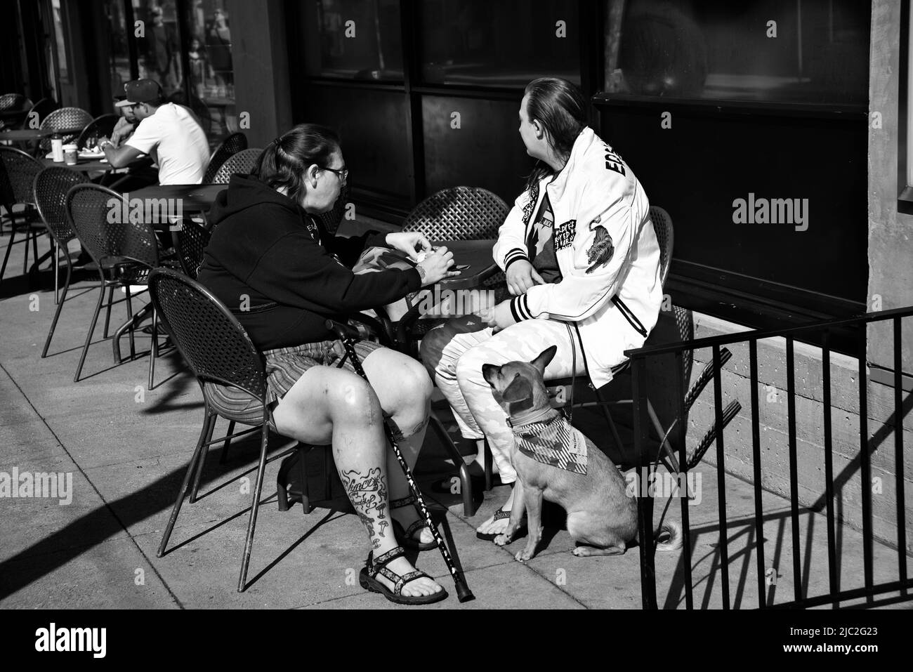 Zwei Frauen genießen das Essen im Freien mit ihrem Hund im beliebten Viertel Fisherman's Wharf in San Francisco, Kalifornien. Stockfoto