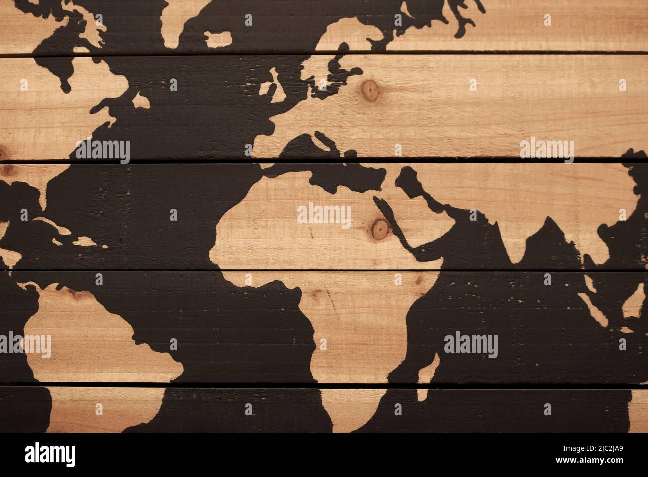 Hintergrund von rauen Holzpflanzen mit Teilansicht der Weltkarte mit Ozeanen dunkelbraun bemalt Stockfoto