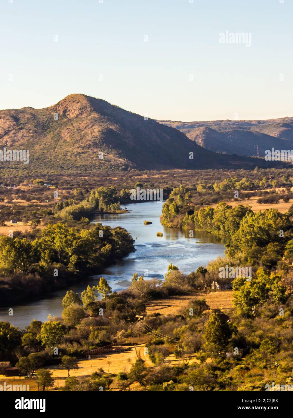 Blick über den Vaal River, der durch die hügeligen Hügel des Vredefort Dome in Südafrika fließt Stockfoto