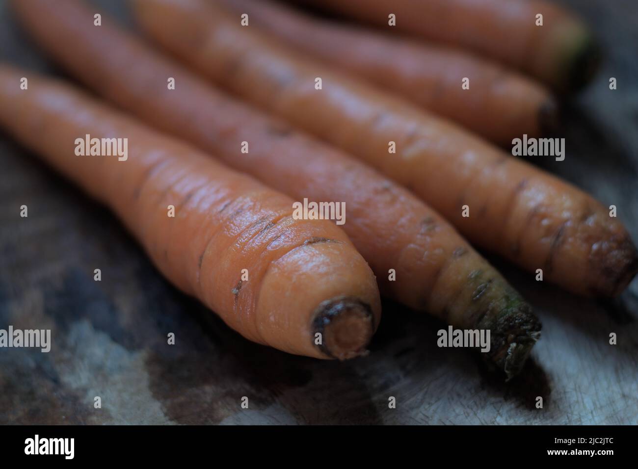 Gewaschene Karotten aus dem Garten auf Holzgesicht, natürliches Licht. Stockfoto