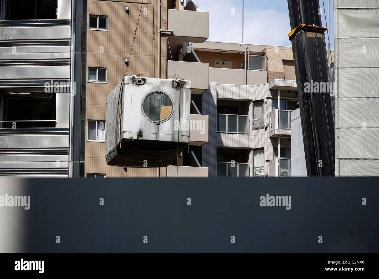 Ein Kran trägt eine Kapsel während des Abrisses am Nakagin Capsule Tower in Ginza am 9. Juni 2022 in Tokio, Japan. Der Rückbau von 140 Einzelkapseln des futuristischen Gebäudes (Mischnutzung Wohn- und Büroturm) wird im Rahmen der Abbrucharbeiten bis Ende dieses Jahres fortgesetzt. Quelle: Rodrigo Reyes Marin/AFLO/Alamy Live News Stockfoto