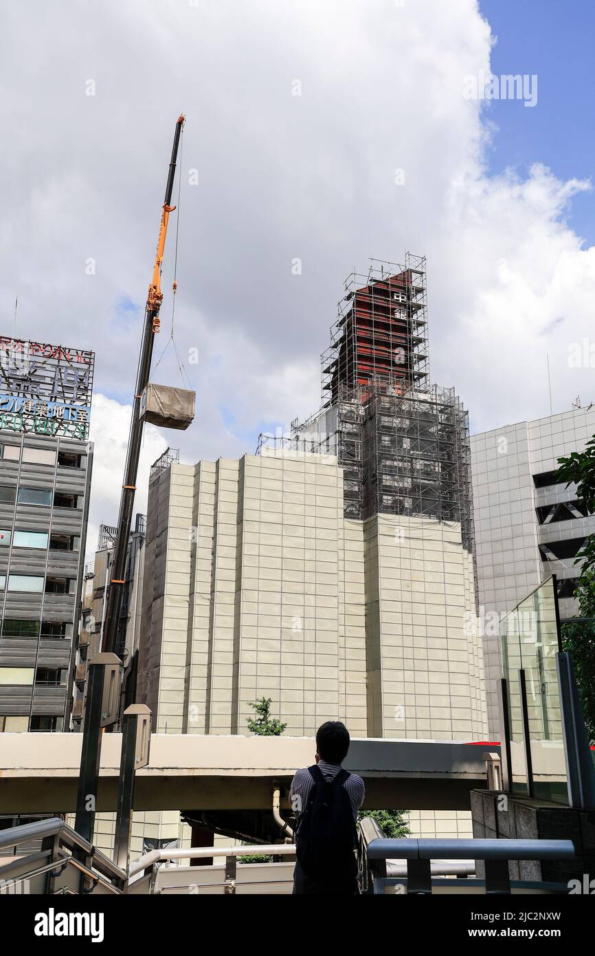 Ein Kran trägt eine Kapsel während des Abrisses am Nakagin Capsule Tower in Ginza am 9. Juni 2022 in Tokio, Japan. Der Rückbau von 140 Einzelkapseln des futuristischen Gebäudes (Mischnutzung Wohn- und Büroturm) wird im Rahmen der Abbrucharbeiten bis Ende dieses Jahres fortgesetzt. Quelle: Rodrigo Reyes Marin/AFLO/Alamy Live News Stockfoto