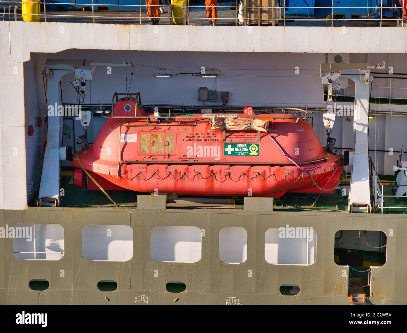 Ein orangefarbenes, gut sichtbareres, startbereites Marine-Rettungsboot und Taucher-Rettungsboot, das zwischen zwei weißen Startdavits auf einer Nordsee-Unterstützungsvesse aufgehängt ist Stockfoto Ein orangefarbenes, gut sichtbareres, startbereites Marine-Rettungsboot und Taucher-Rettungsboot, das zwischen zwei weißen Startdavits auf einer Nordsee-Unterstützungsvesse aufgehängt ist Stockfoto