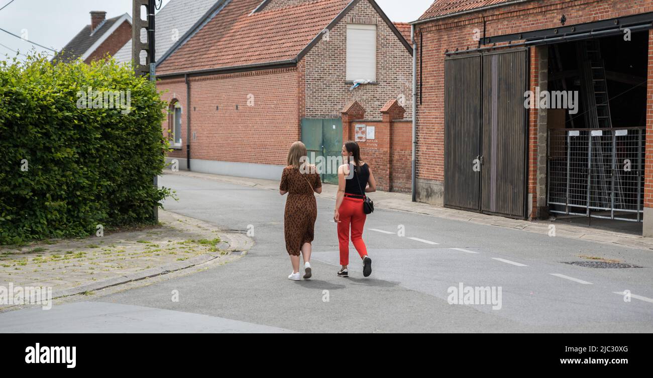 Lebbeke, Flandern - Belgien - 05 25 2020 zwei atbarktive Jugendliche Gymnasiasten, die durch das Dorf laufen Stockfoto