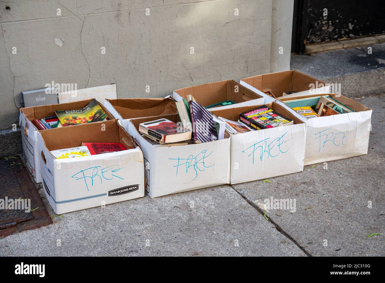 Kostenlose Bücher in Kartons, die vor einem Wohngebäude in der Upper West Side in New York City, USA, zurückgelassen wurden Stockfoto