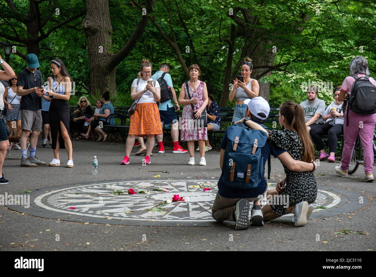 Touristen, die Fotos am John Lennon Memorial machen oder Imagine Mosaic im Central Park, New York City, Vereinigte Staaten von Amerika Stockfoto