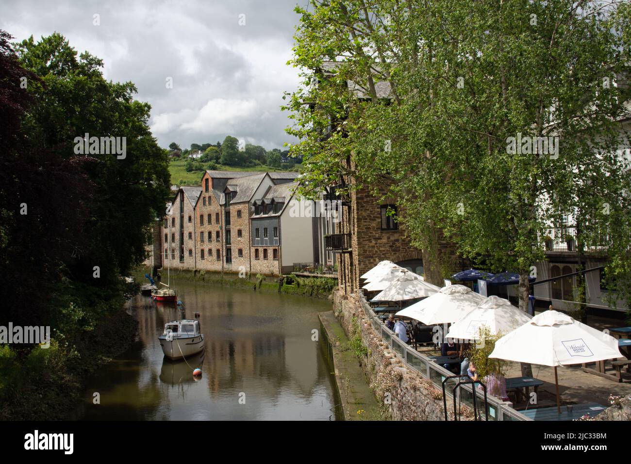 TOTNES, Großbritannien - 26. JUNI 2021 an einem bewölkten Tag vertäuten Boote, Gebäude und Geschäfte auf dem berühmten Mill Tail of the River Dart Stockfoto