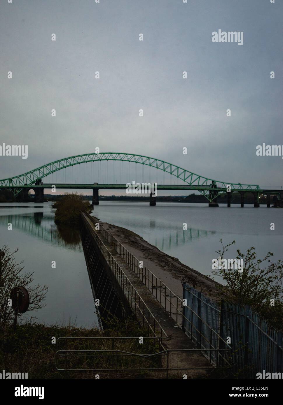 Runcorn Bridge / Silver Jubilee Bridge in Runcorn, Großbritannien, reflektiert im Wasser. Stockfoto