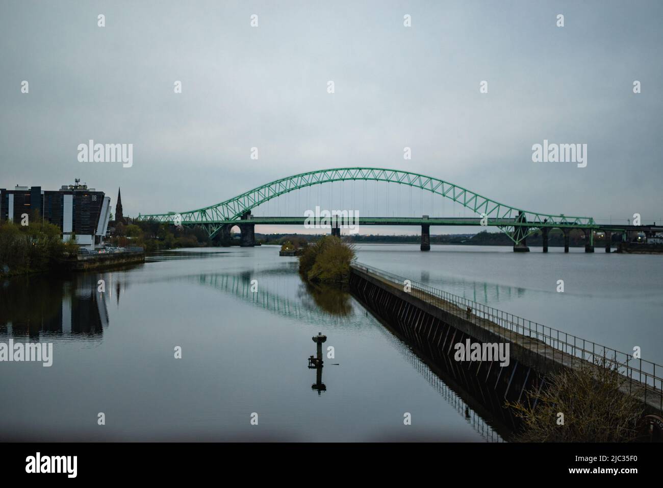 Runcorn Bridge / Silver Jubilee Bridge in Runcorn, Großbritannien, reflektiert im Wasser. Stockfoto