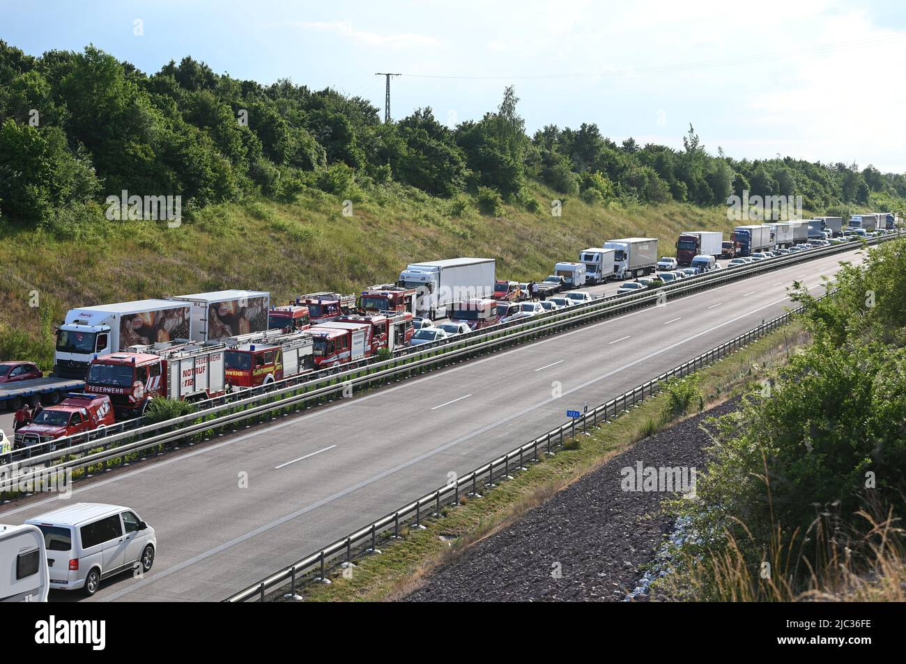09. Juni 2022, Sachsen-Anhalt, Halle/Saale: Viele Einsatzkräfte arbeiten am Unfallort auf der Autobahn 14 bei Halle, der Verkehr steht dahinter. Am Donnerstag kam es am A14 bei Halle zu einem schweren Unfall mit mehreren Verletzten. Nach Angaben der Polizei waren zwei Autos und zwei Transporter an dem Unfall zwischen den Kreuzungen Trotha und Tornau beteiligt. Foto: Heiko Rebsch/dpa Stockfoto