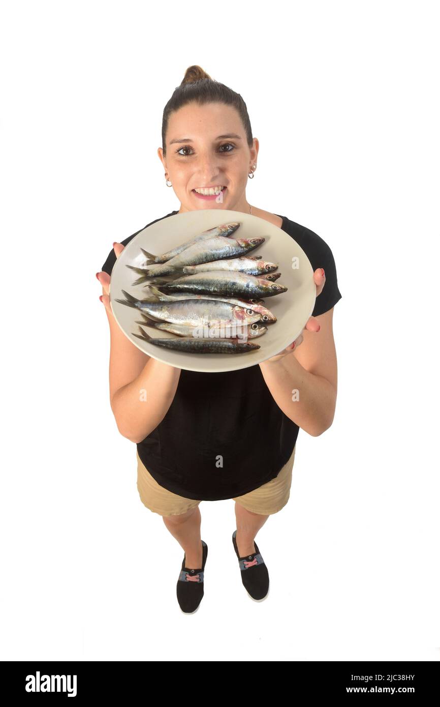 Frau zeigt einen Teller mit Sardinen Stockfoto