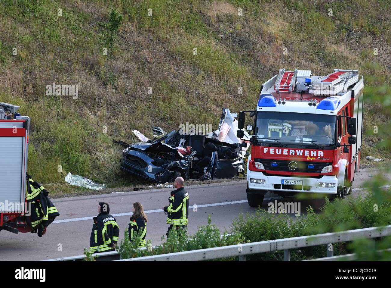 09. Juni 2022, Sachsen-Anhalt, Halle/Saale: Feuerwehrleute sind am Unfallort auf der Autobahn 14 bei Halle im Einsatz. Bei einem schweren Unfall am A14 bei Halle sind am Donnerstag drei Menschen ums Leben gekommen. Das teilte die Polizei mit. Zwei Autos und zwei Transporter waren an dem Unfall zwischen den Kreuzungen Trotha und Tornau beteiligt. Foto: Heiko Rebsch/dpa Stockfoto